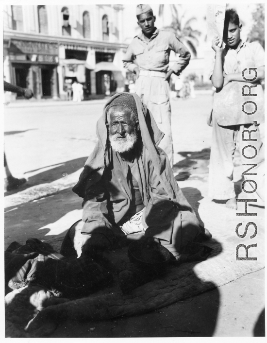 Old man begs on road in town in Burma or India.  Near the 797th Engineer Forestry Company.  During WWII.