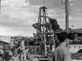 Local people in Yunnan, China: A construction site, using a small wooden derrick to drive in piles or dig a well. During WWII.