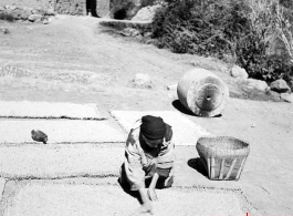 A woman drying grain in a village in Yunnan province, China. During WWII.