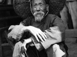 Local people in China during WWII: An elderly man sitting. During WWII.