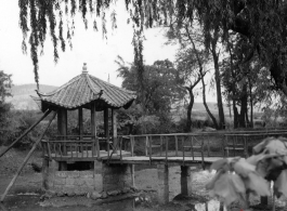 Local scene in Yunnan province, China: A small pavillion over a dried pond in a Chinese town.