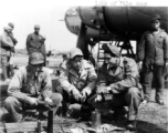 Sgt. Andrew R. Allegretto chats with Chinese airmen, with a B-25 in the background. Sgt. Allegretto received the Air Medal for flying on a hazardous mission as part of the "Spray and Pray Squadron," part of CACW.