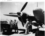 GIs move supplies between a truck and a F-5 (P-38)--not usually considered a cargo carrier--including a box labeled "Curtiss Candy Co." along with cartons of "plum base." In the CBI during WWII.   Photo from W. T. Basore.
