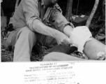 An American doctor treats a leg injury in on site in the forest in the CBI during WWII.  Photo from John E. Clark.