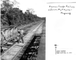 GI shoot rifle from bridge on narrow-gauge railway between Myitkyina and Mogaung, during WWII.  Photo from Henry Behner.