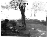 Men working metal in shade of tree.  Scenes in India witnessed by American GIs during WWII. For many Americans of that era, with their limited experience traveling, the everyday sights and sounds overseas were new, intriguing, and photo worthy.