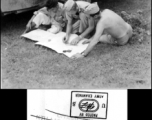 GIs looking at map next to their camouflaged jeep. In China during WWII.