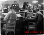 Tightly packed radio room in the CBI during WWII, with American GIs busy at the equipment.
