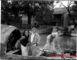 Young Chinese family in a boat travels by, during WWII.